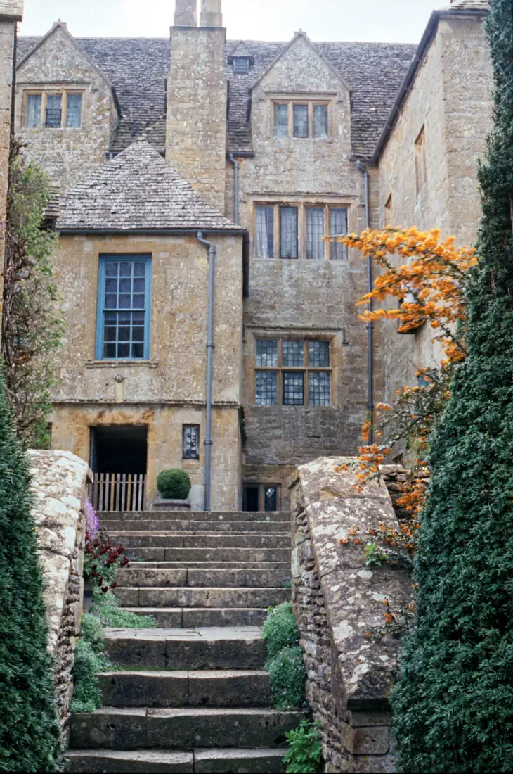 Stone steps rising between walls to a stone manor house