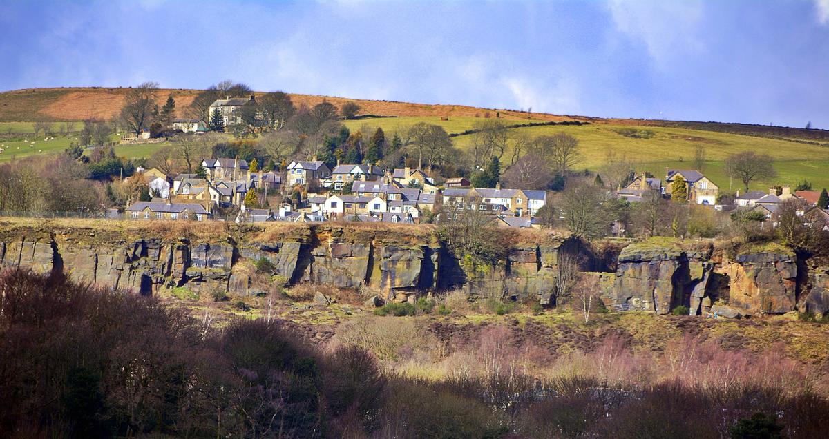 A sandstone quarry face above a West Yorkshire village